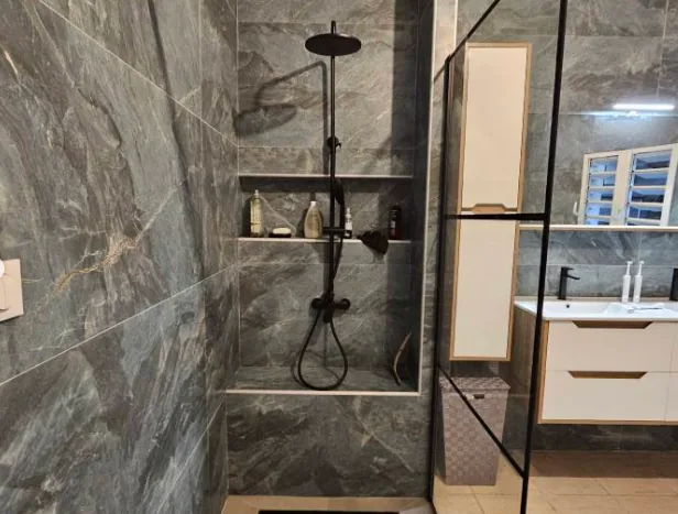 Salle de bain en carrelage effet marbre avec douche à l'italienne et niche de rangement