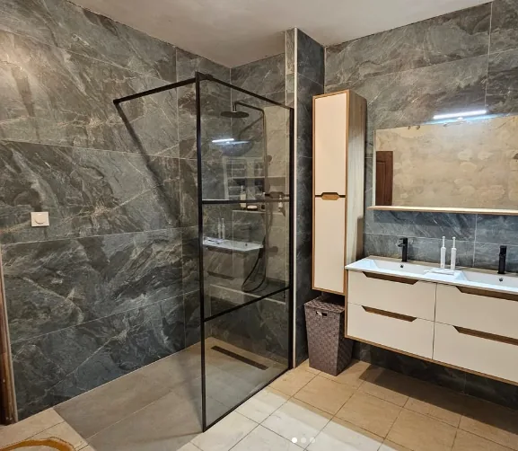 Salle de bain carrelée effet marbre avec douche à l'italienne vitrée
